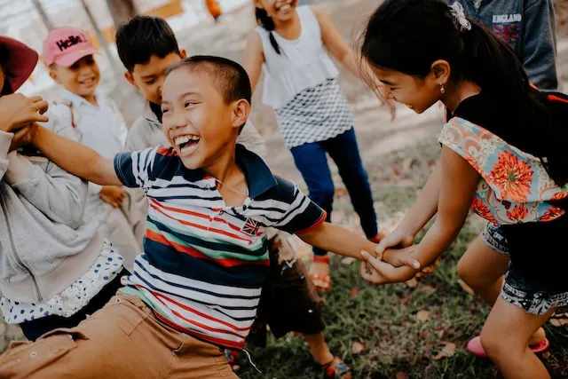 a group of Vietnamese children playing outside holding hands