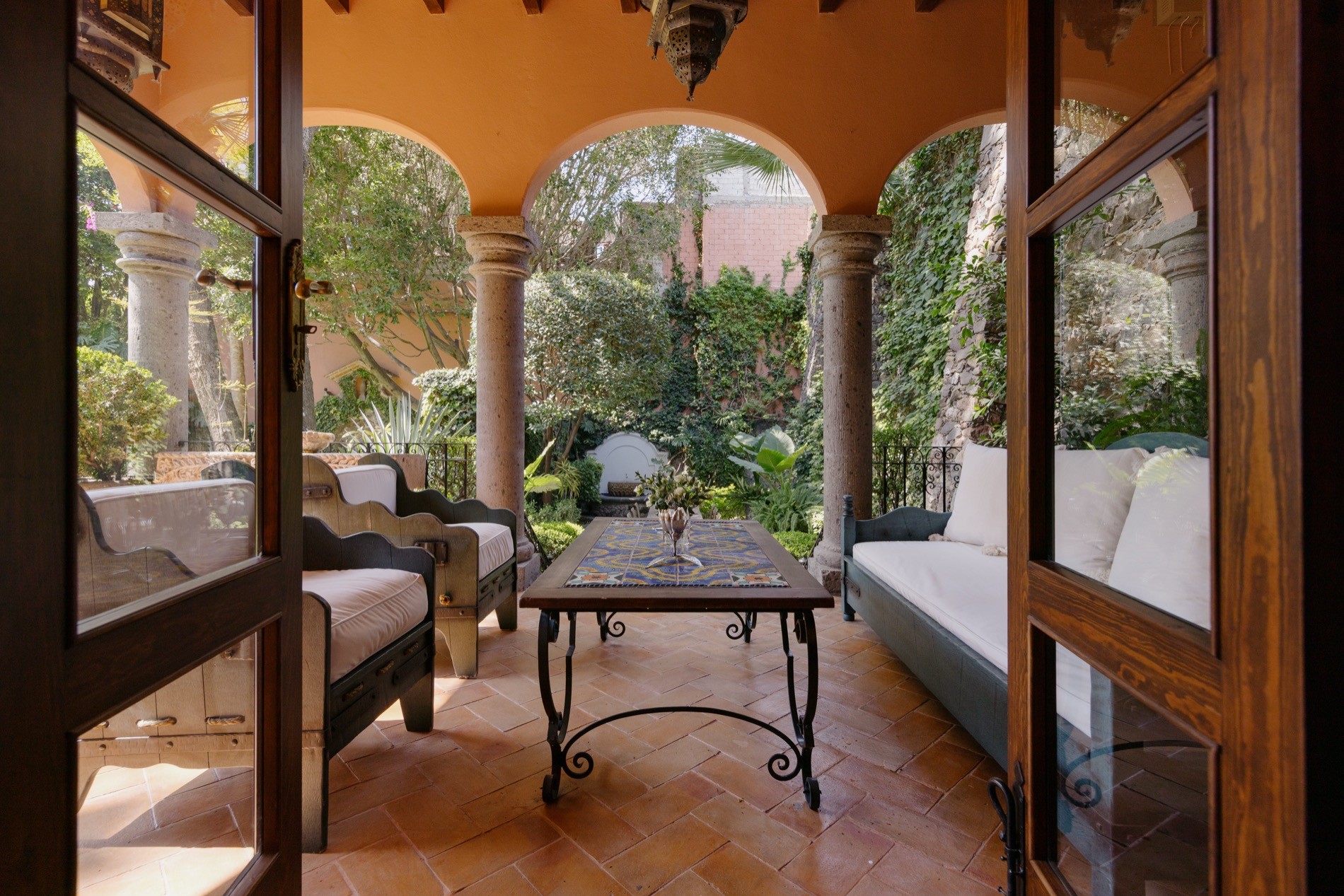 La Residencia San Miguel sculpted garden hedges with pool and stone sculptures beyond