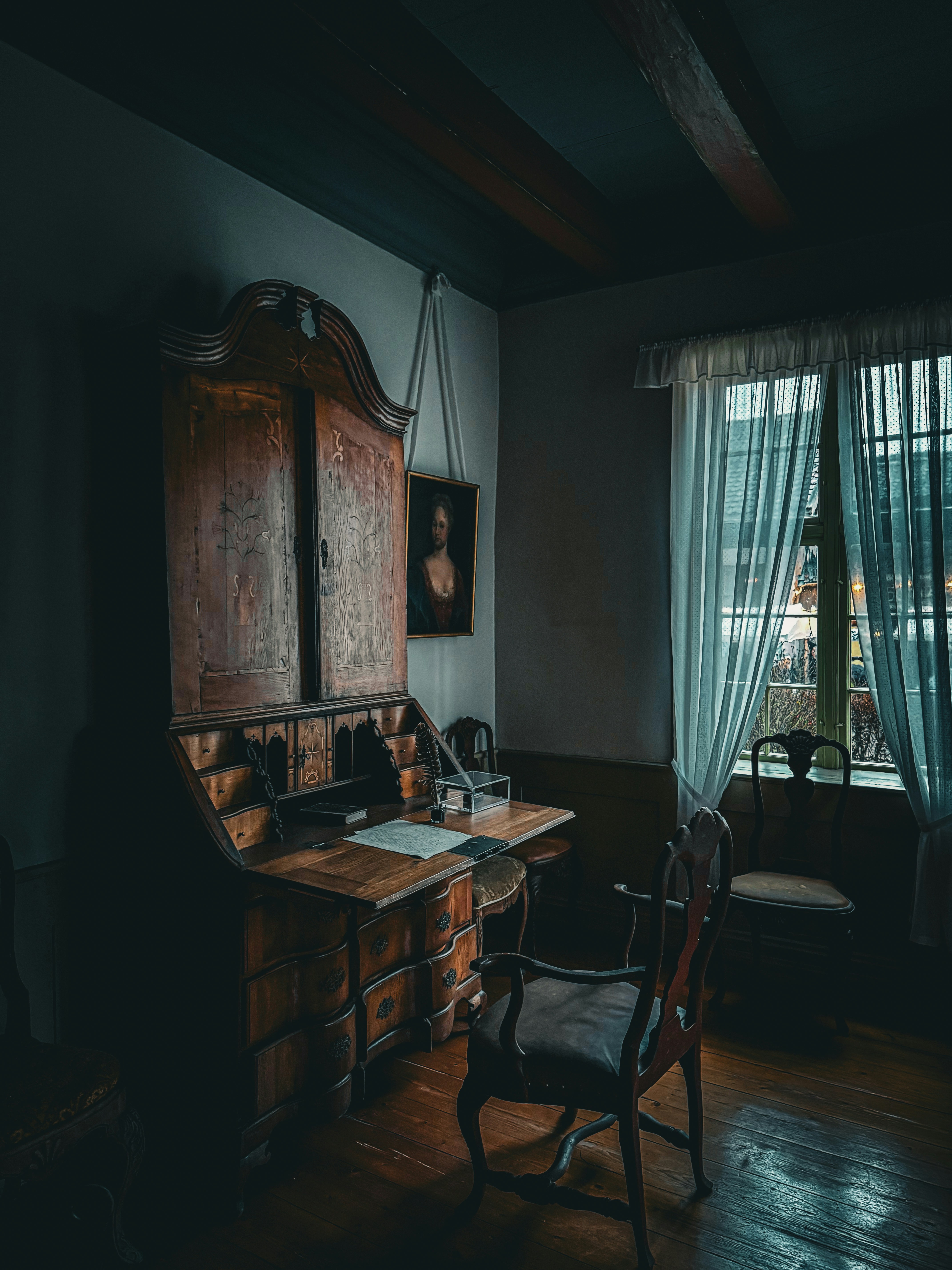 A dark, old-fashioned desk in a dimly lit room.