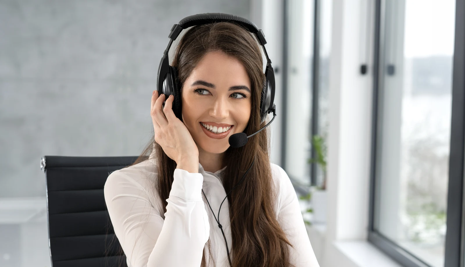 Smiling professional wearing a headset in a light filled office