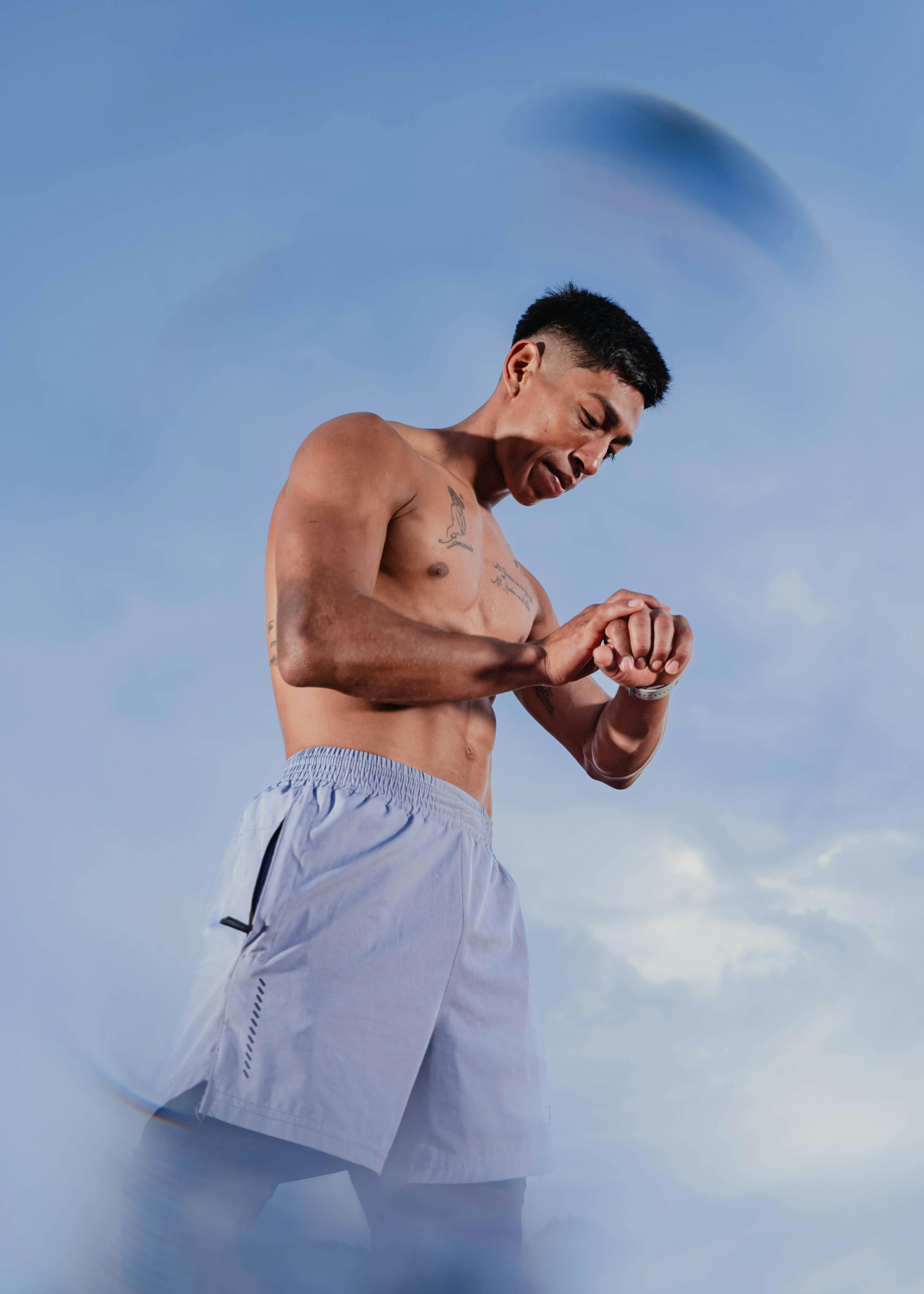 Man shirtless looking at his watch