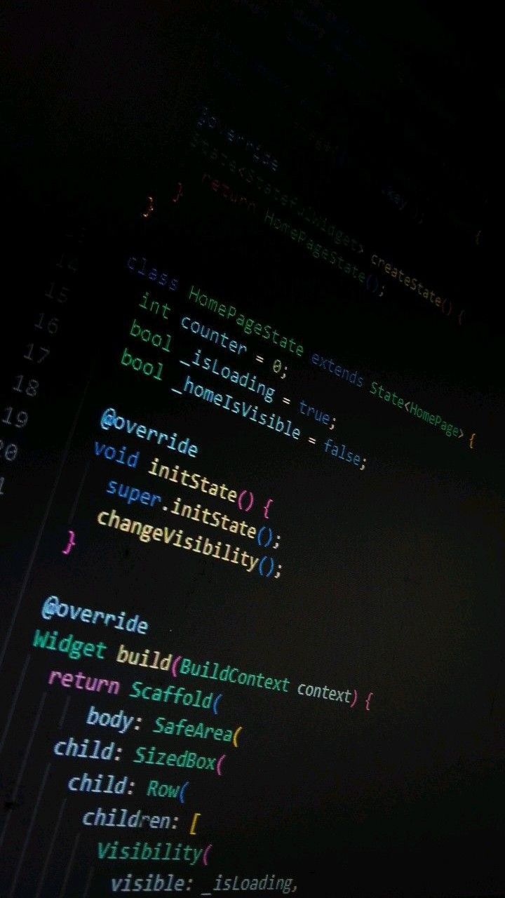 A young man with dark hair smiles at the camera, set against a modern indoor background.