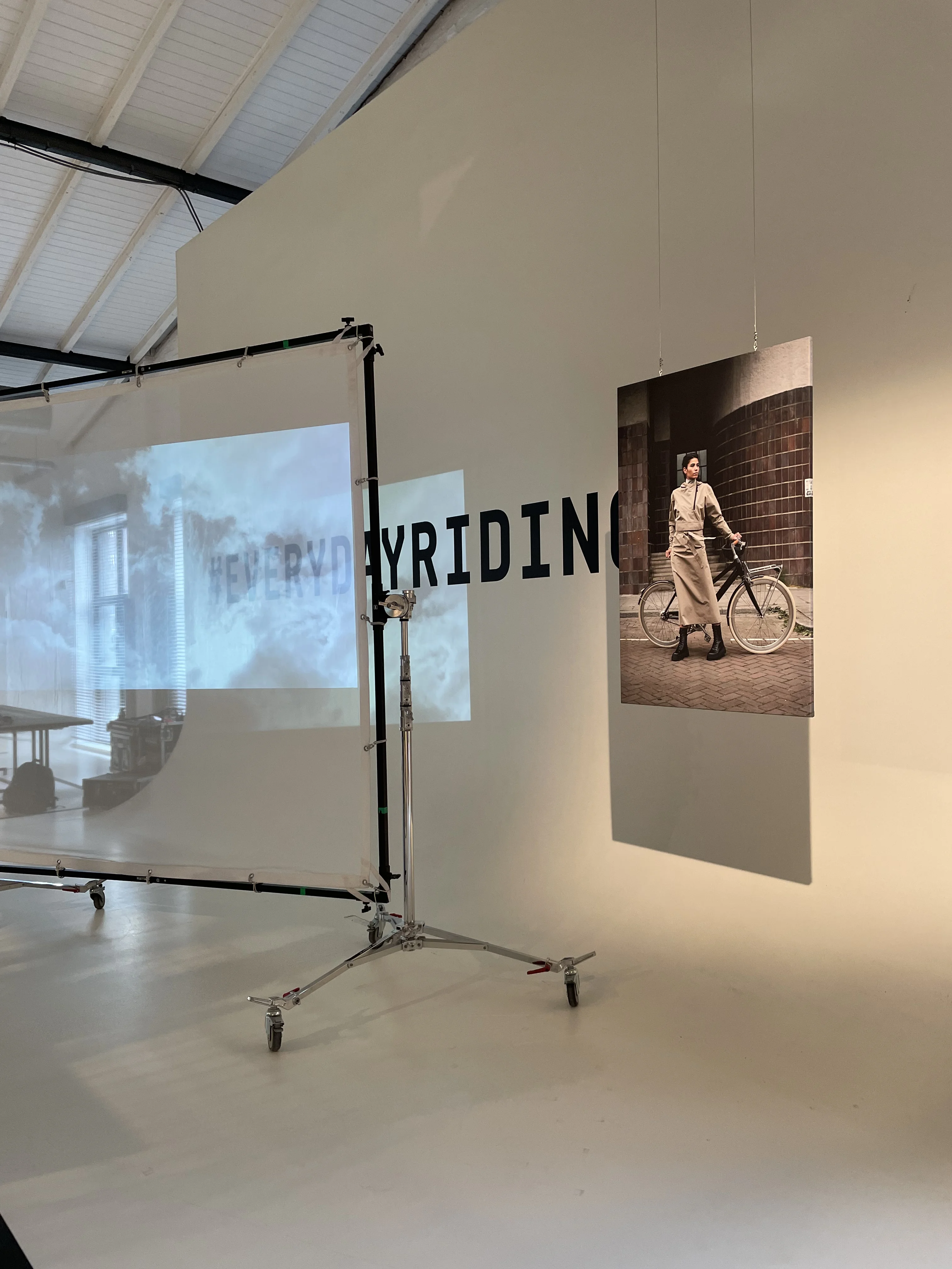 Projection screen and hanging vintage cycling photograph beside the #everydayriding lettering at the AGU exhibition.