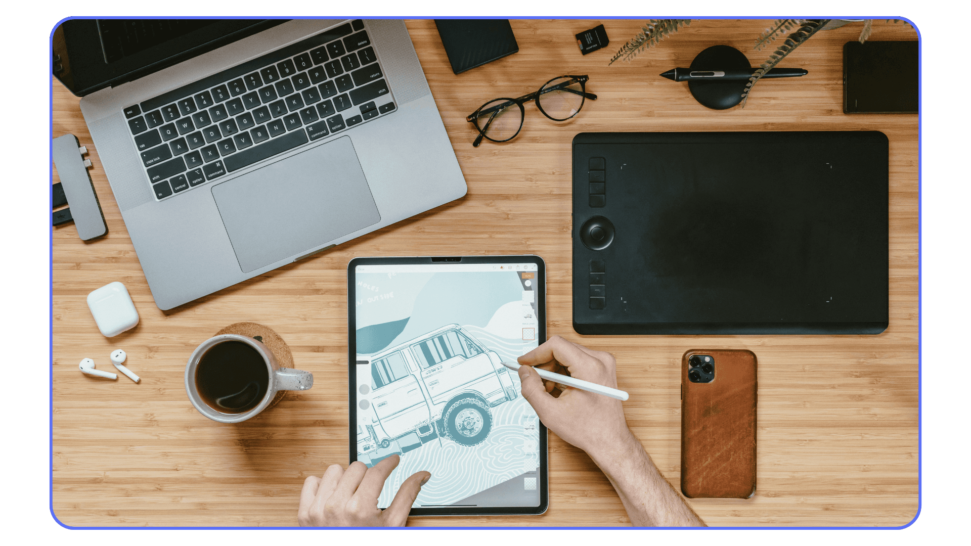 Digital art workspace with laptop, drawing tablet, and tablet used for illustration work