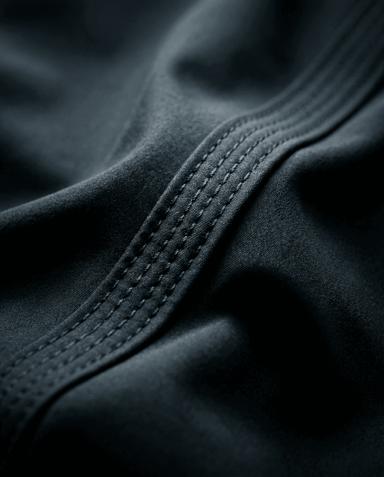 photo of gray sewing machine foot lock with thread on black cloth