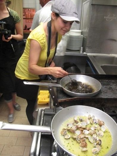 A photo of a woman taking a taste sample in a kitchen.