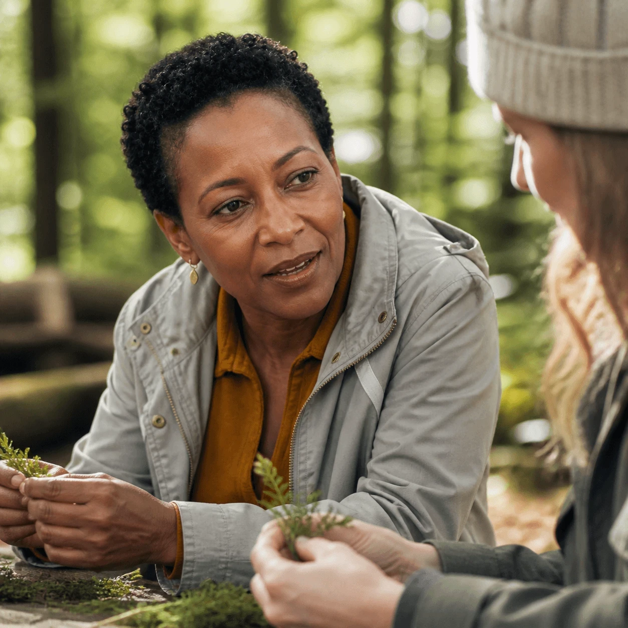 Participante échangeant avec une autre personne en forêt.