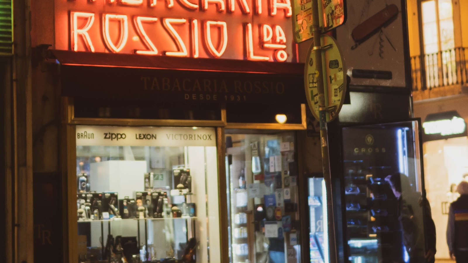 Neon-lit shop entrance in Lisbon at night