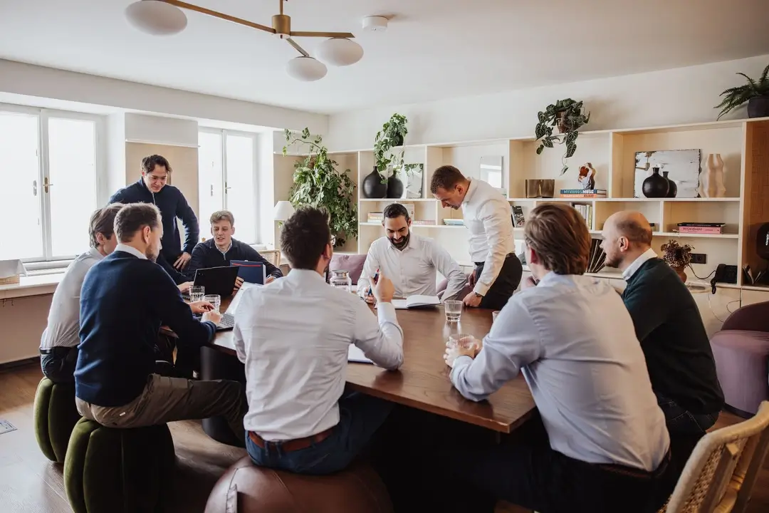 Professionelle Gastronomie- & Interieur-Fotografie: Gemütliche Lounge-Ecke mit rotem Sessel und beleuchteter Wein-Präsentation, inszeniert mit warmem Ambient-Licht und Fokus auf Design-Details.