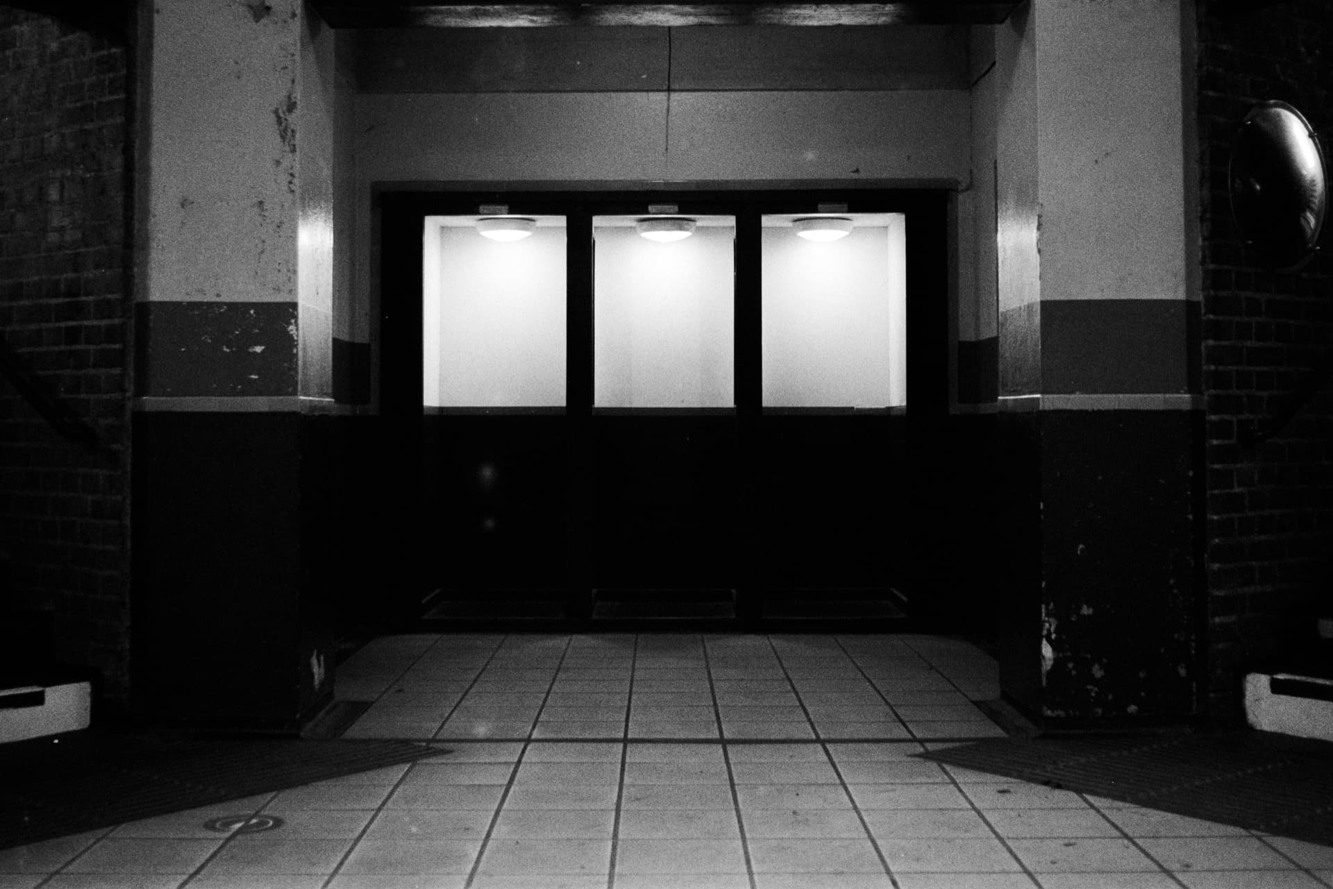 Three illuminated telephone booth enclosures on Underground station platform