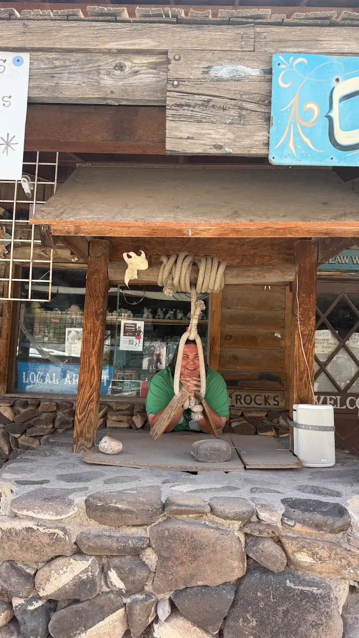 Sara standing in front of Outlaw Willie’s in Oatman, Arizona, wearing a novelty noose and smiling.