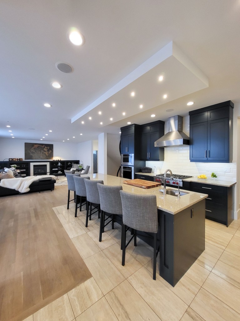 Image of Modern kitchen with island seating, dark cabinets, and luxury interior design by KHD Homes builder.