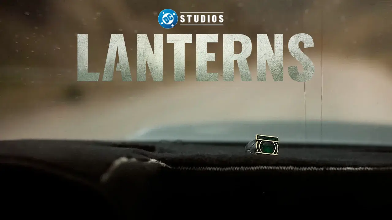 A ring with a green lantern emblem sits on a car dashboard with a blurred road in the background, overlaid with the DC Studios logo and the title "Lanterns."