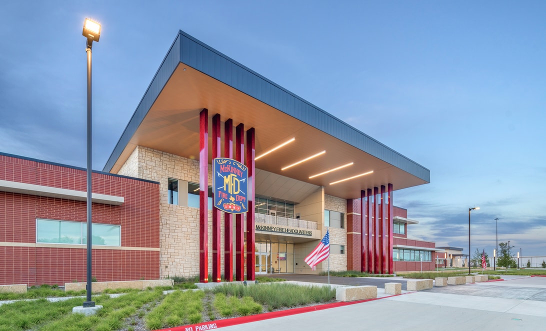 Exterior detail with red vertical fins and the department crest at McKinney Fire Department Headquarters, by Martinez Architects