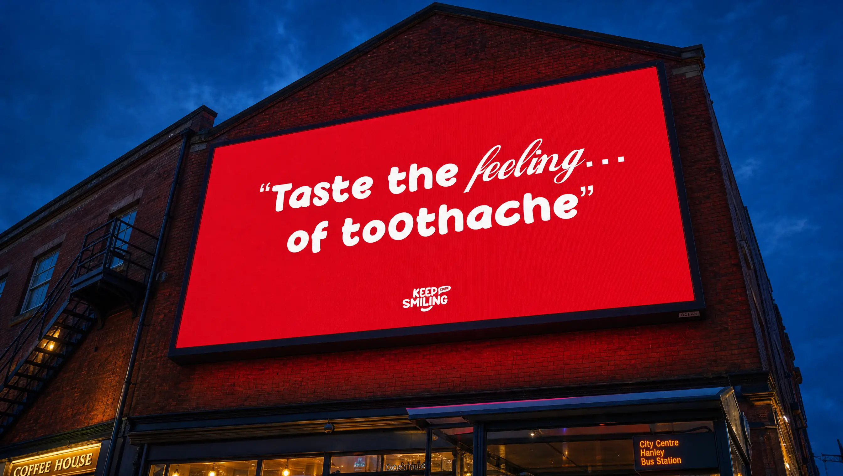 Red "Taste the feeling… of toothache" billboard lit up on a building at dusk