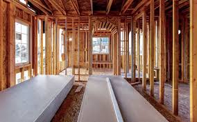 Interior framing of a house with drywall sheets on the floor