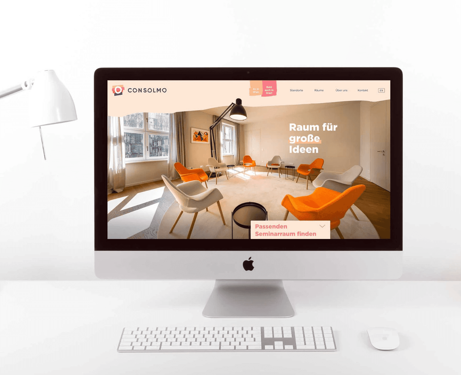 Website von Consolmo auf Desktop-Computer mit Übersicht von Seminarräumen und Call-to-Action zur Buchung