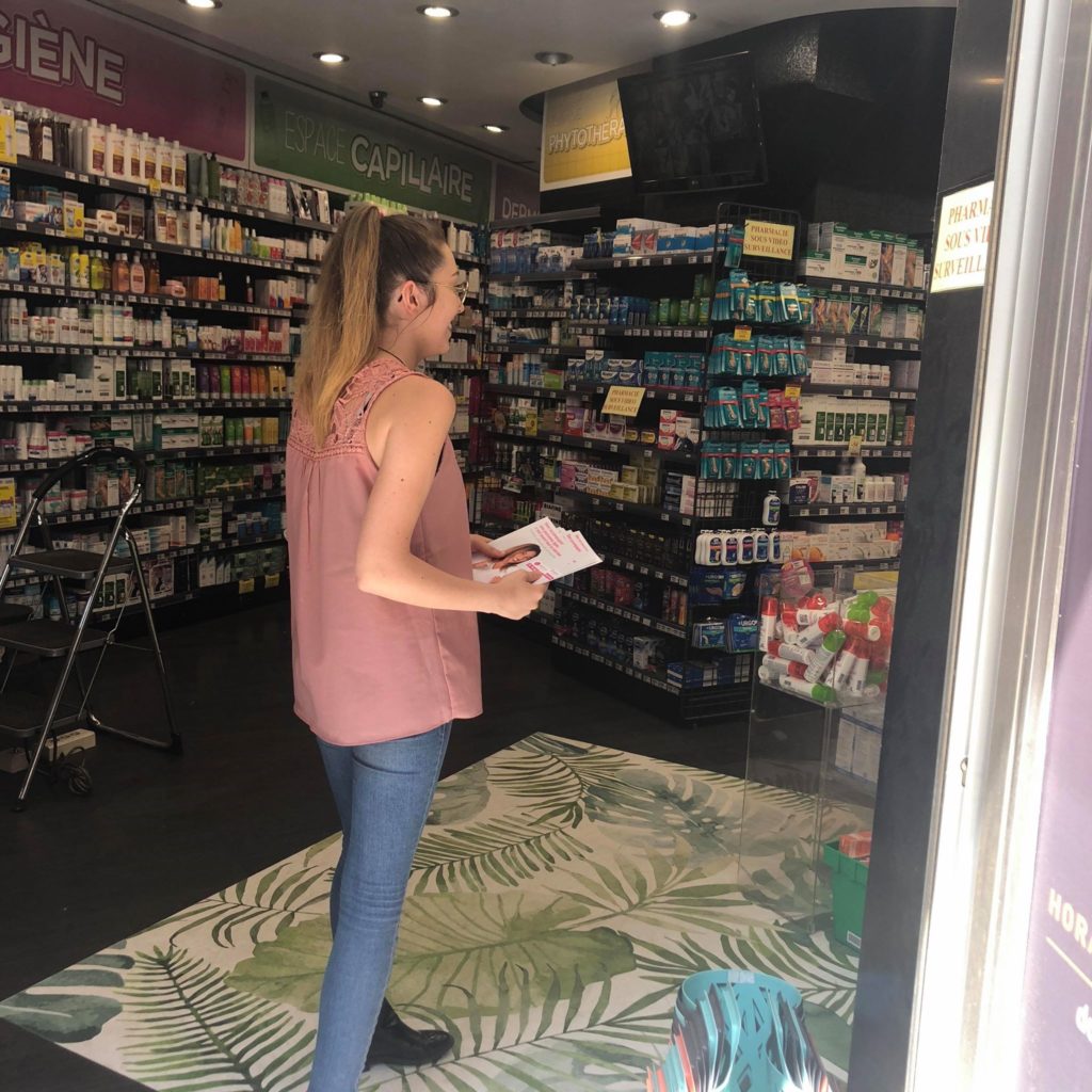 Une professionnelle dépose des brochures dans une pharmacie