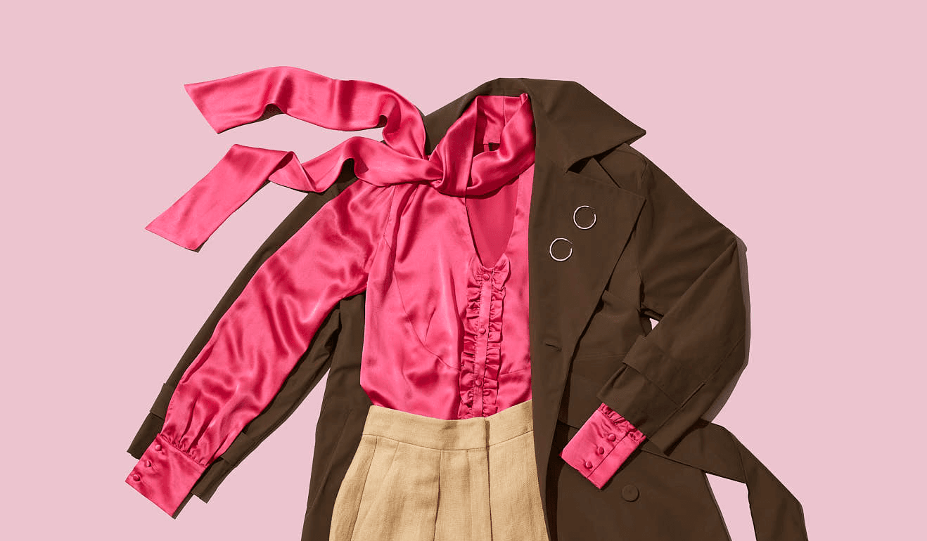 Stylish brown coat paired with a vibrant pink satin blouse and beige skirt on a pink background.
