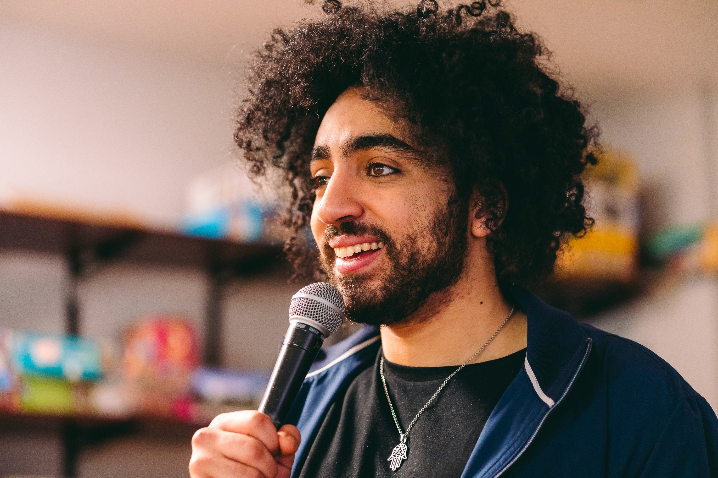 Anas Hassouna tient un micro et sourit.