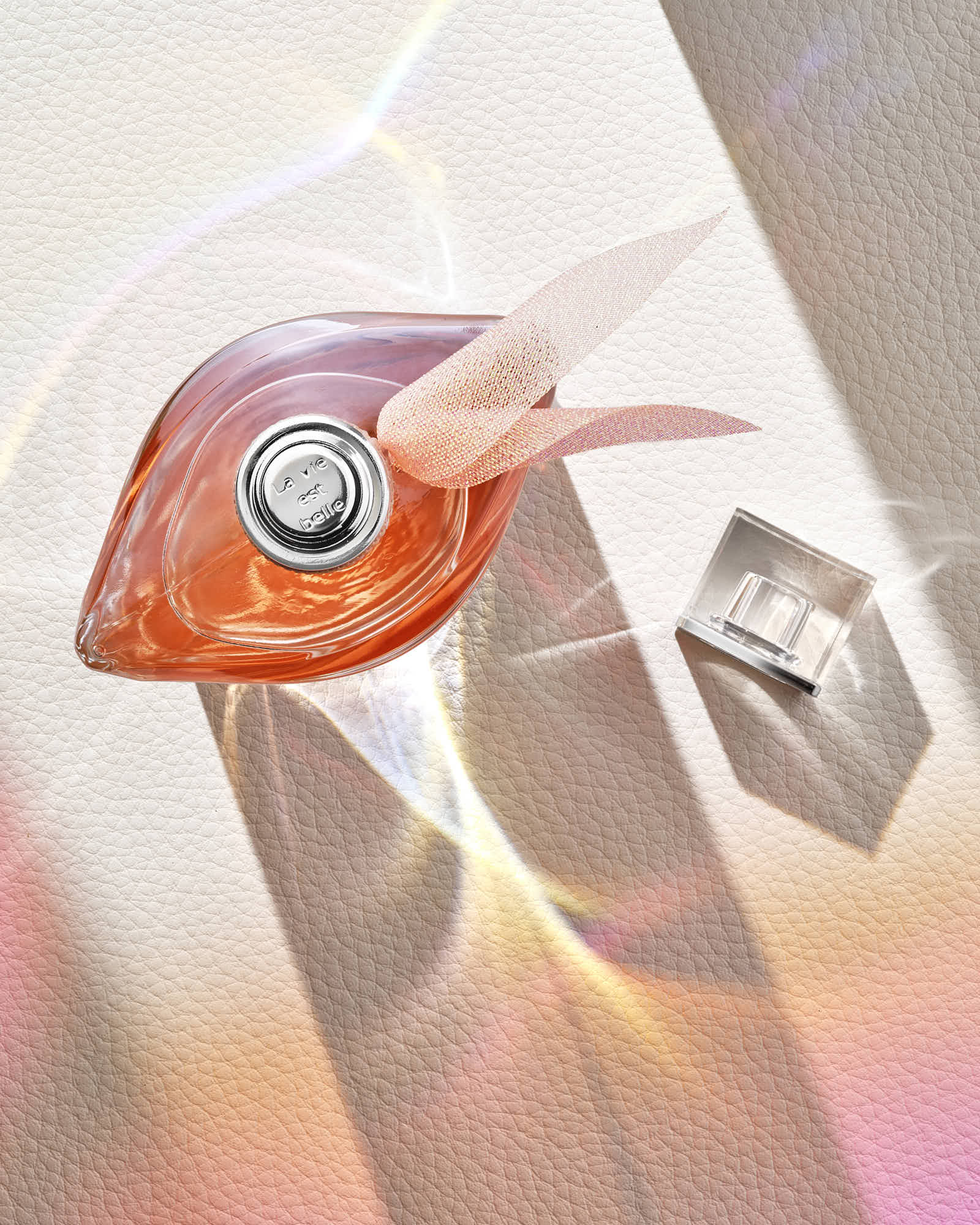 Abstract image featuring a perfume bottle and geometric shapes in soft pastel colors.