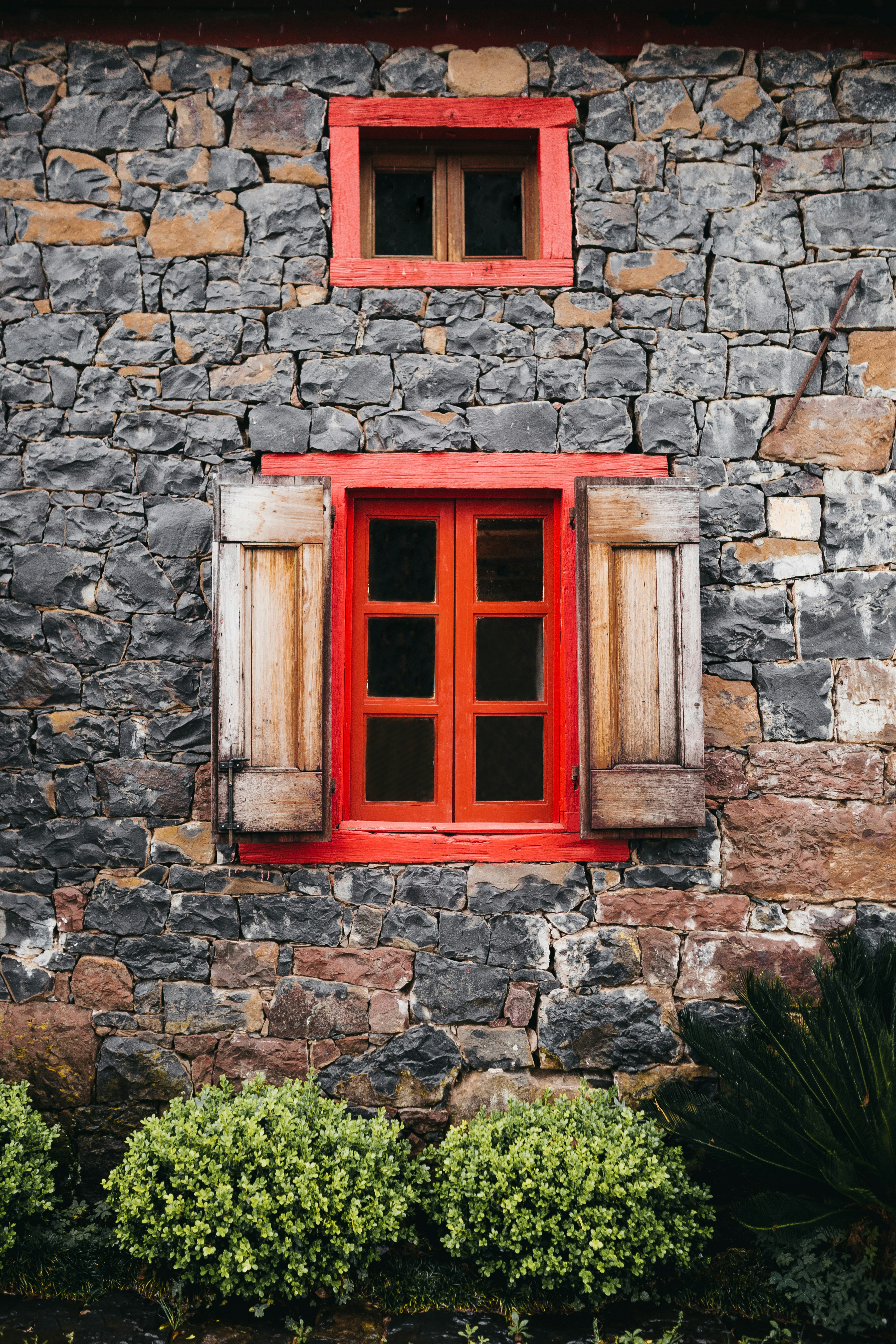 Rotes Holzfenster in Steinwand