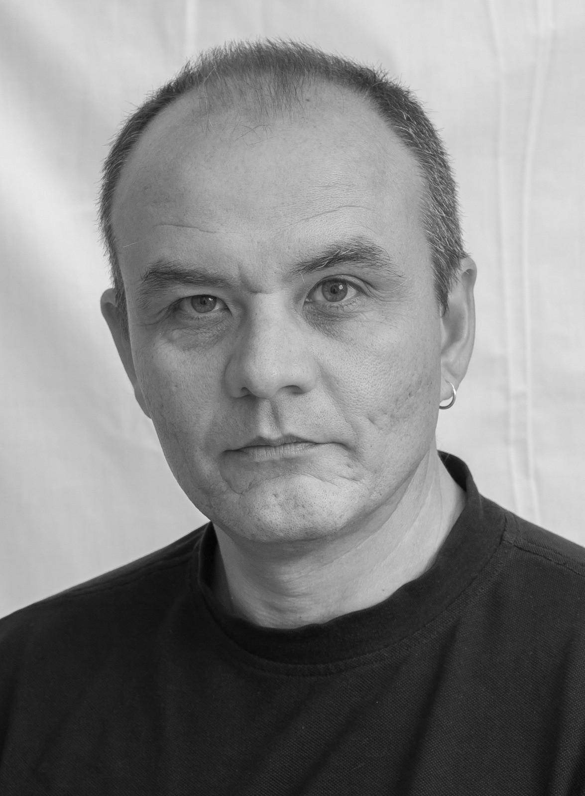 Retrato en blanco y negro de hombre sin barba y camisa negra