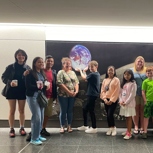 Families stop for photos in front of the "View from the Moon" during the Astroville Tunnel tour of Downtown Houston.