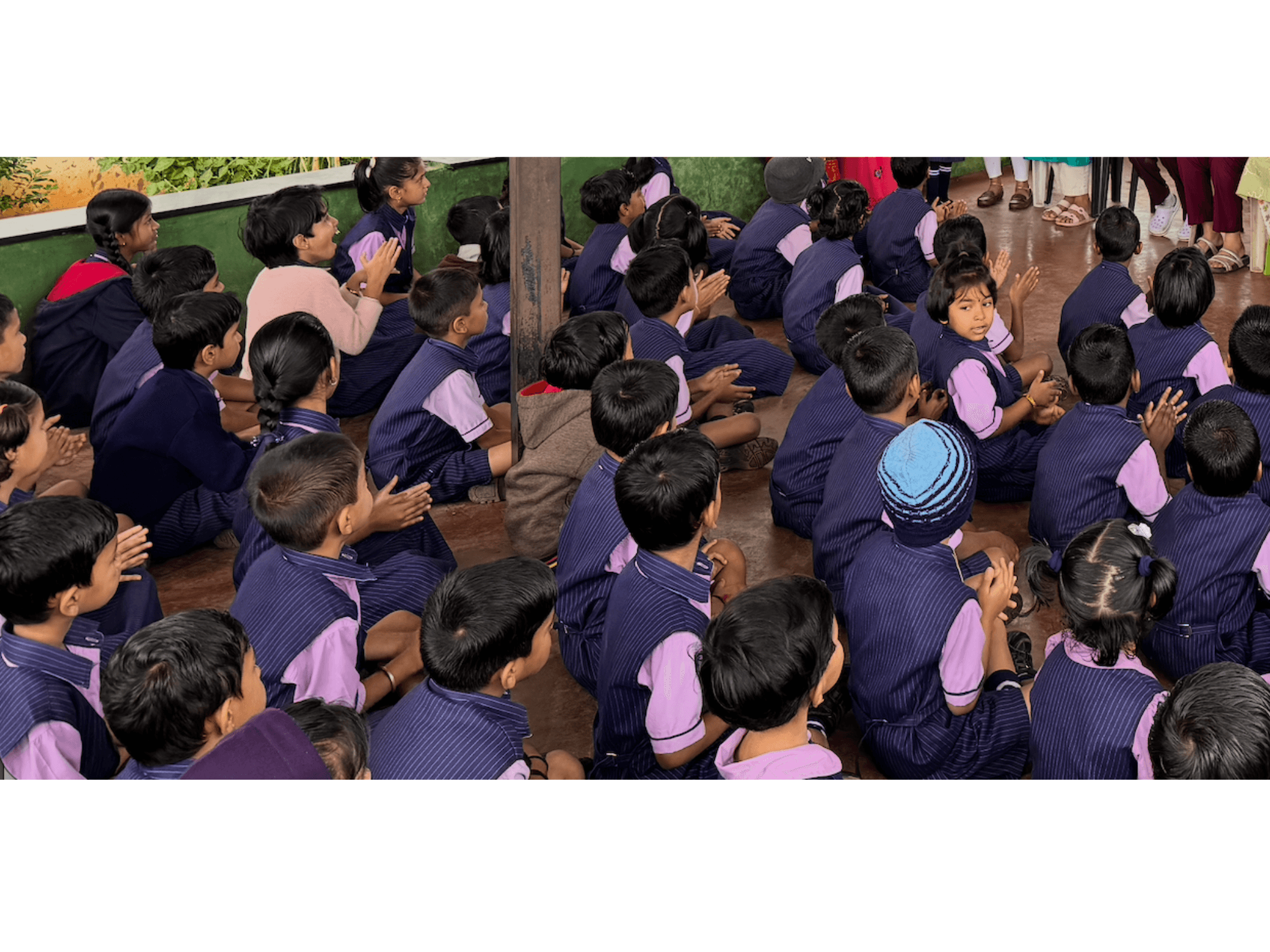four boys laughing and sitting on grass during daytime