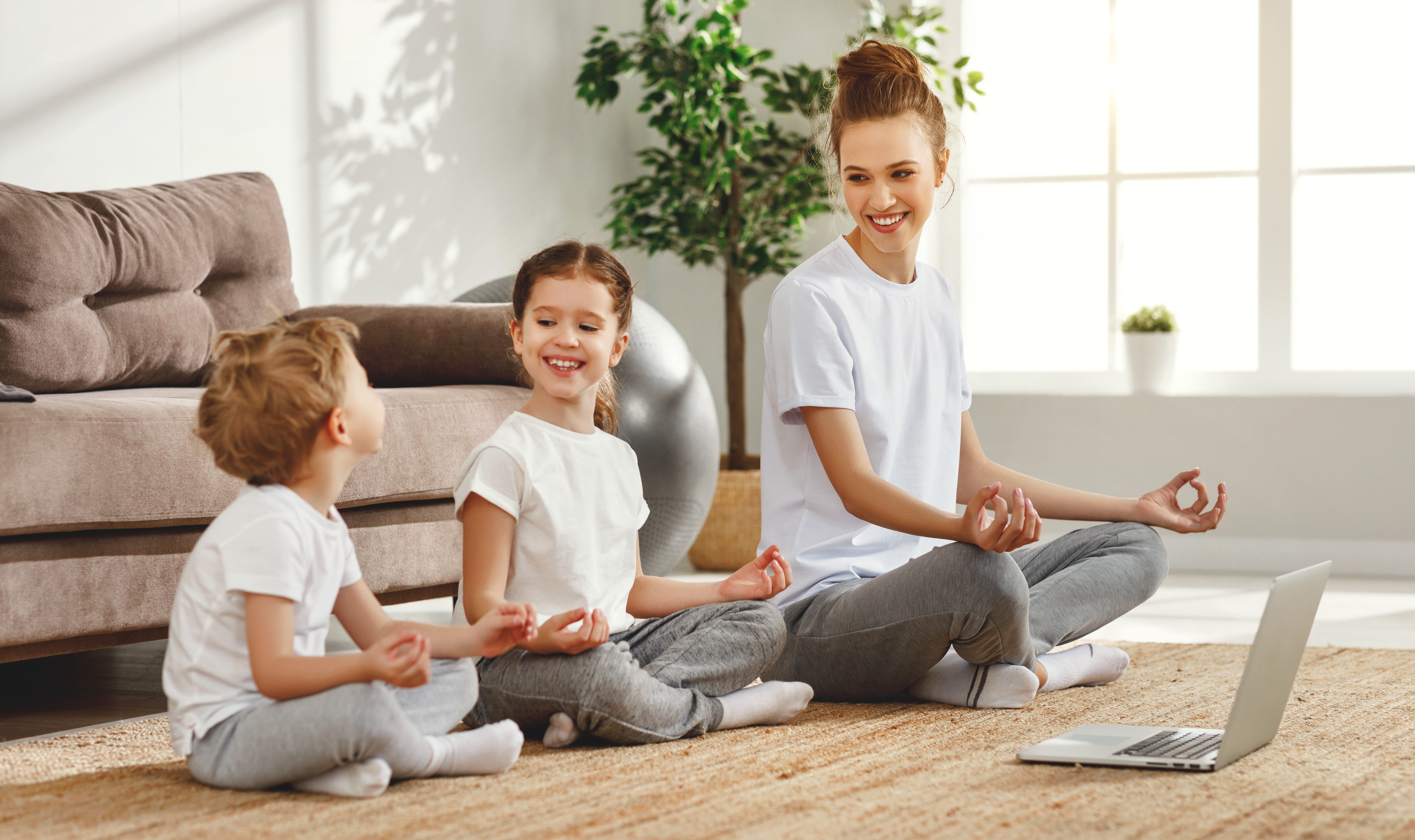 Parent and two children meditating together at home