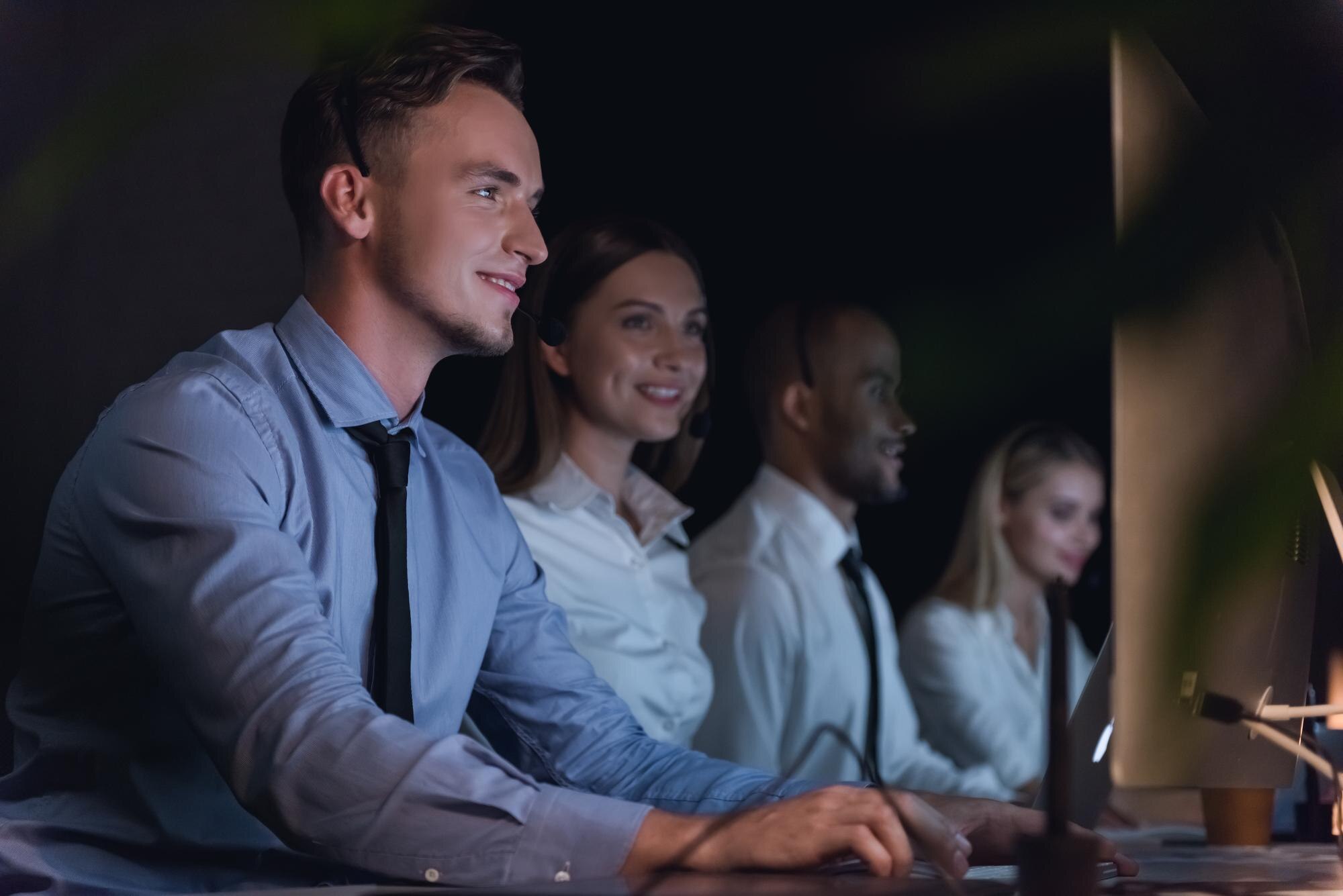 4 individuals sit at their desks, working happily