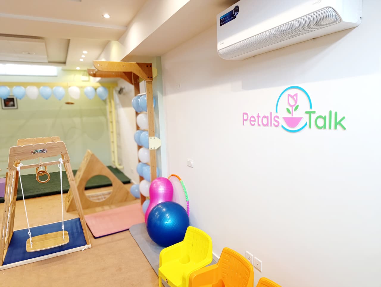 PetalsTalk clinic movement room with wooden activity equipment and clinic branding