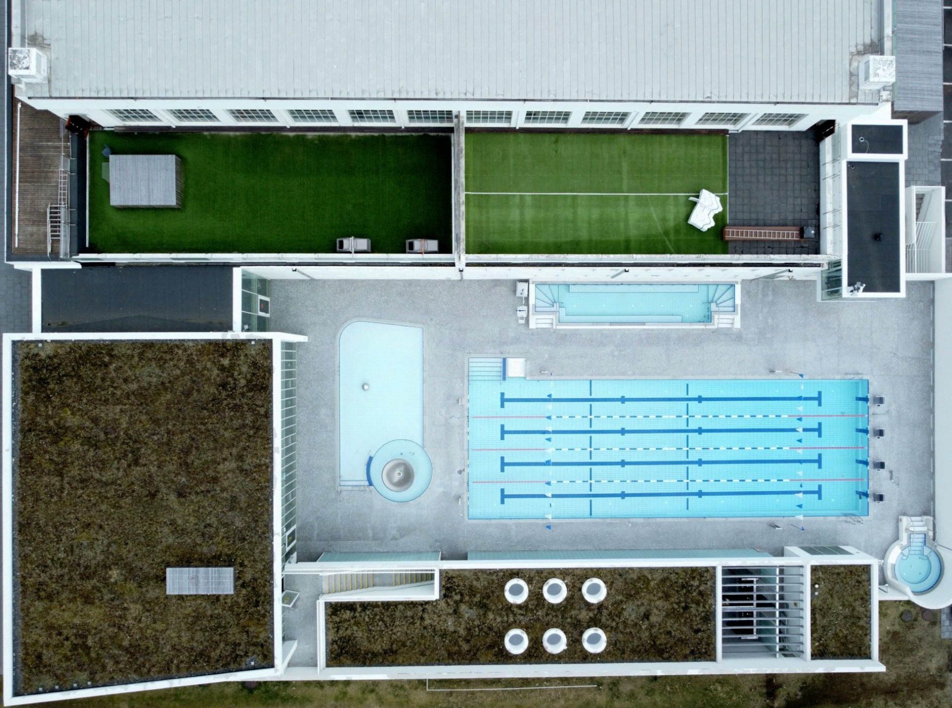 Aerial view of Sundhöll Reykjavíkur showing the outdoor swimming pool, hot tubs, and rooftop sun deck in downtown Reykjavík.
