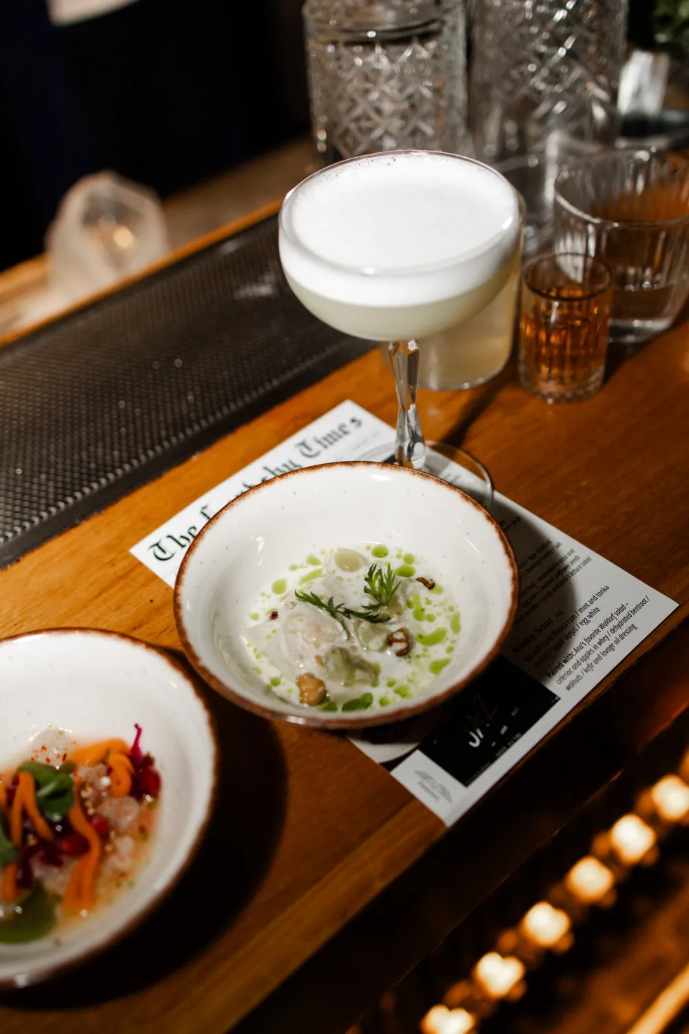 A phone, pad, and pen sit on a wooden desk.