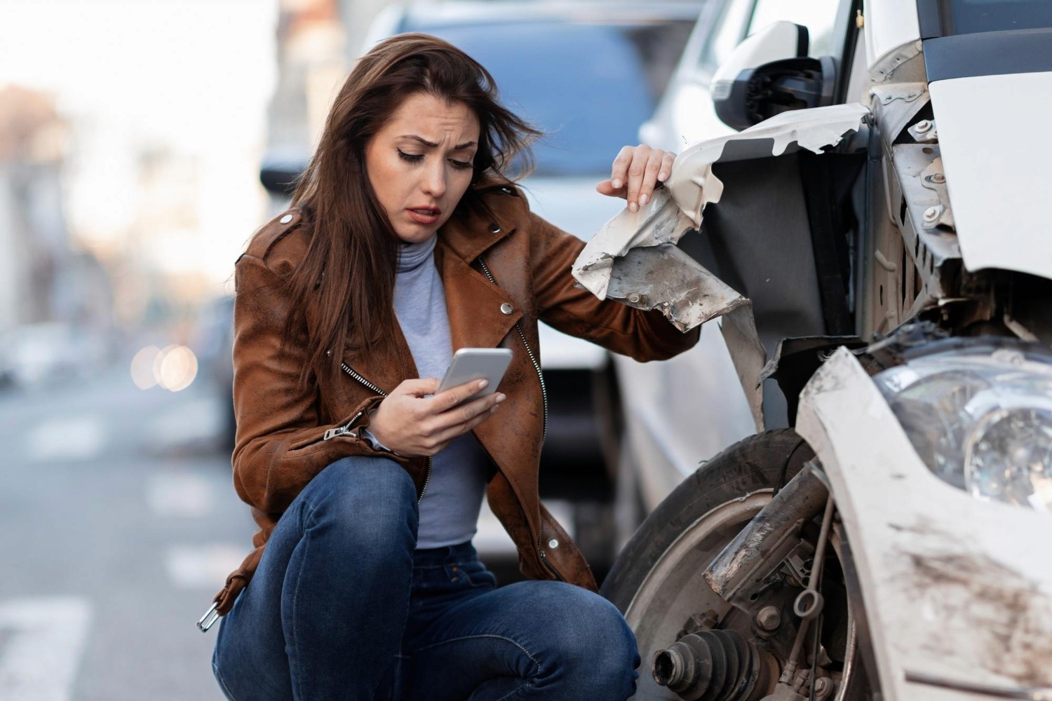  Young woman making a phone call after a car accident