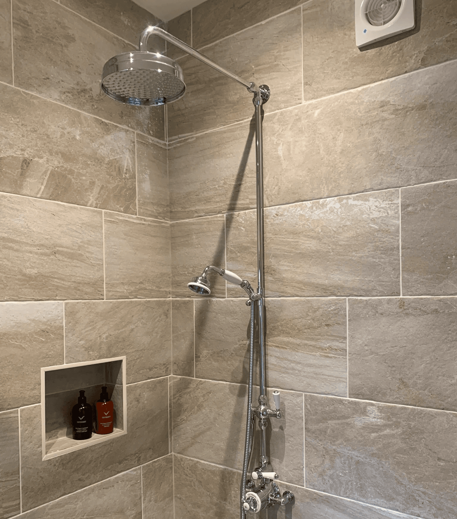 Stainless steel shower fittings in tiled shower enclosure