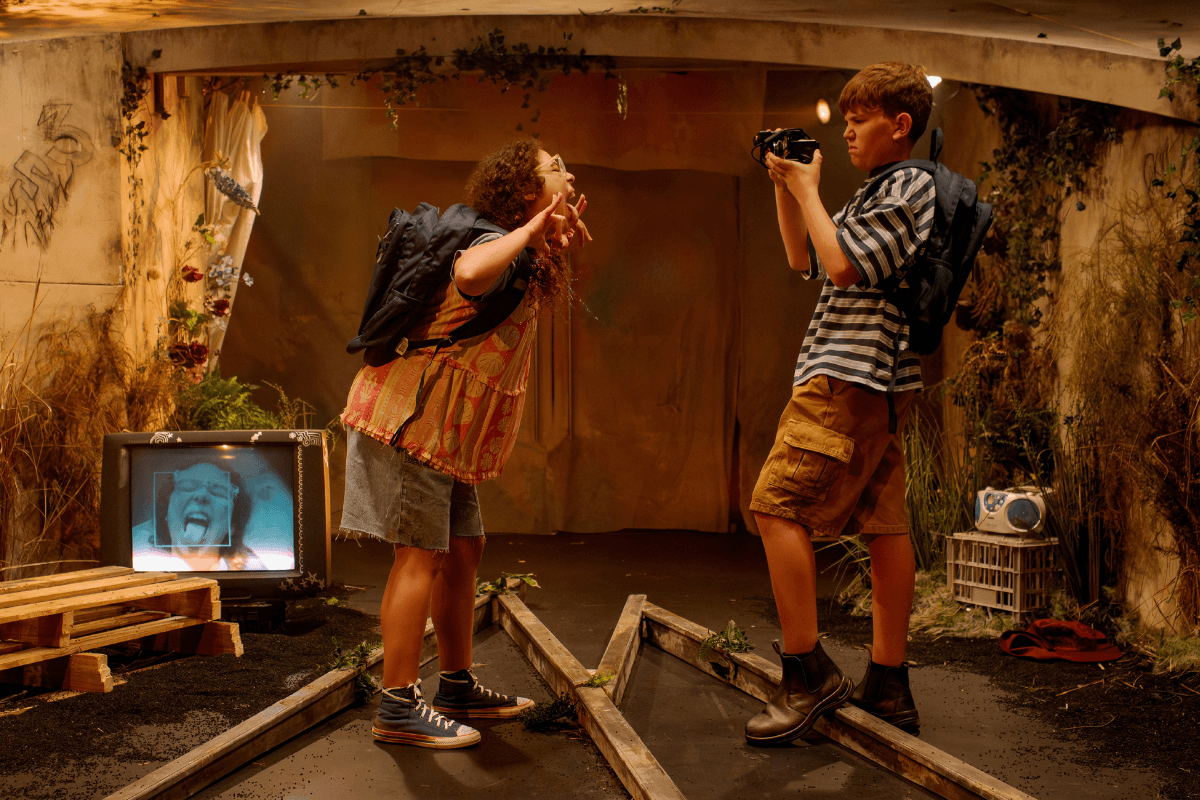 A boy filming a girl making a face to the camera