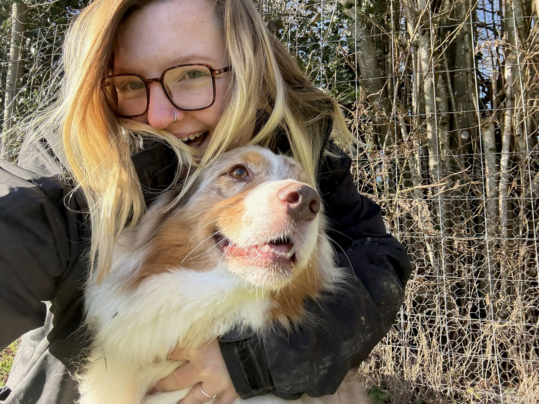 Paige (co-founder of Pickles Dog Daycare) posing smiling with a happy looking dog
