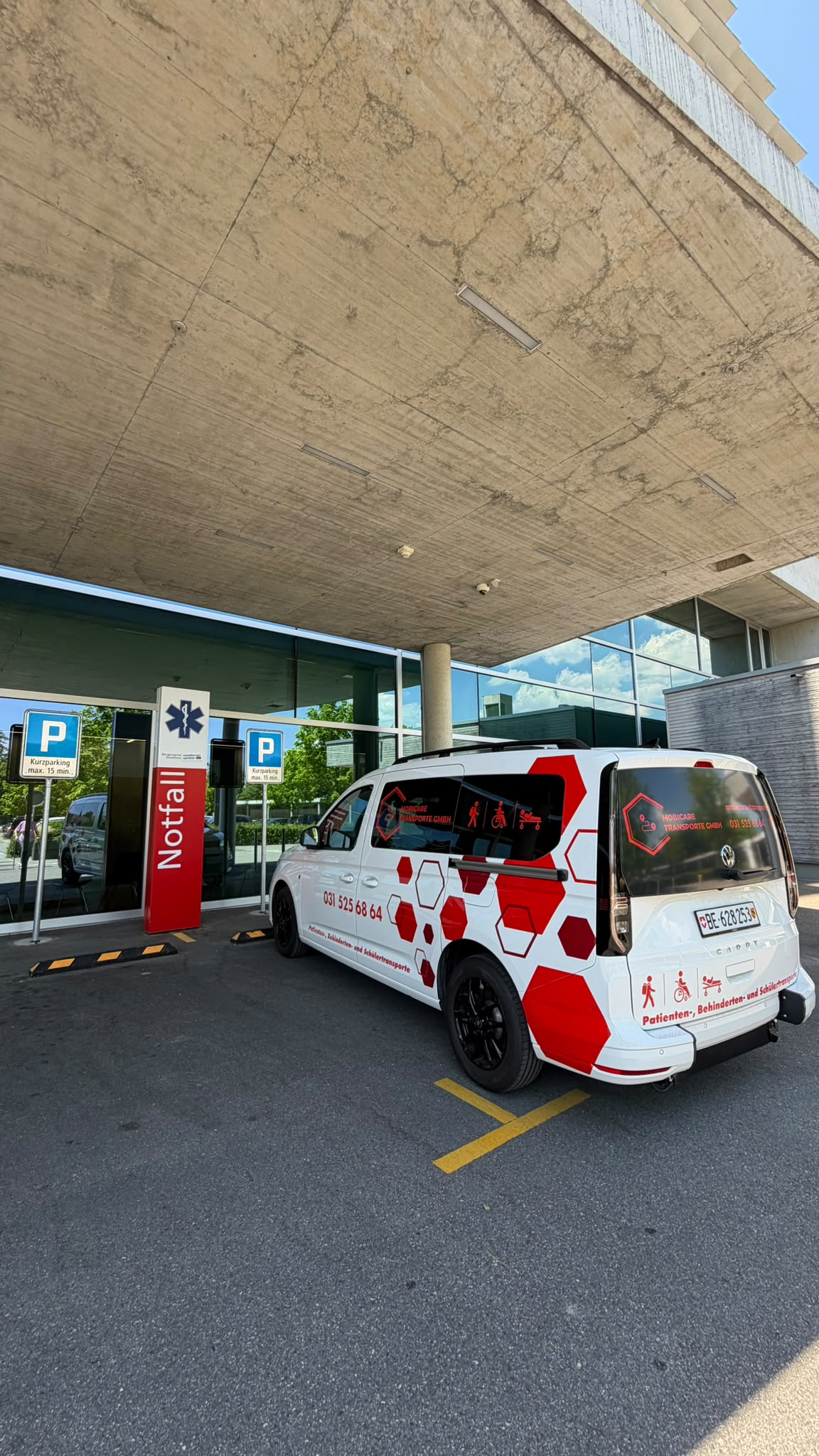 Personentransportfahrzeug von MobiCare vor der Notfallaufnahme eines Spitals