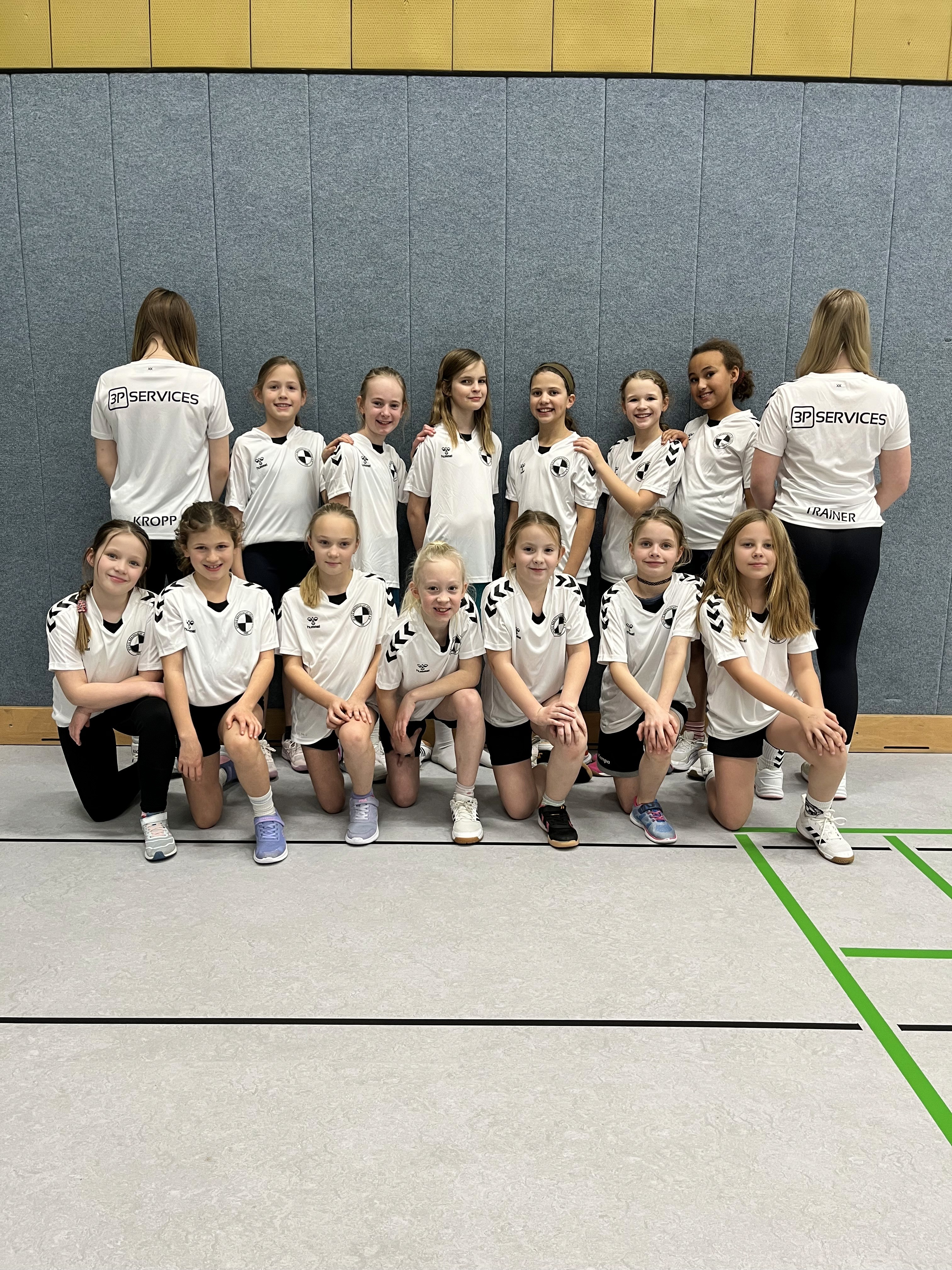 Attendees sit at a booth promoting 30+ years of IJJ experience. Booth includes signage, product images, and brochures.