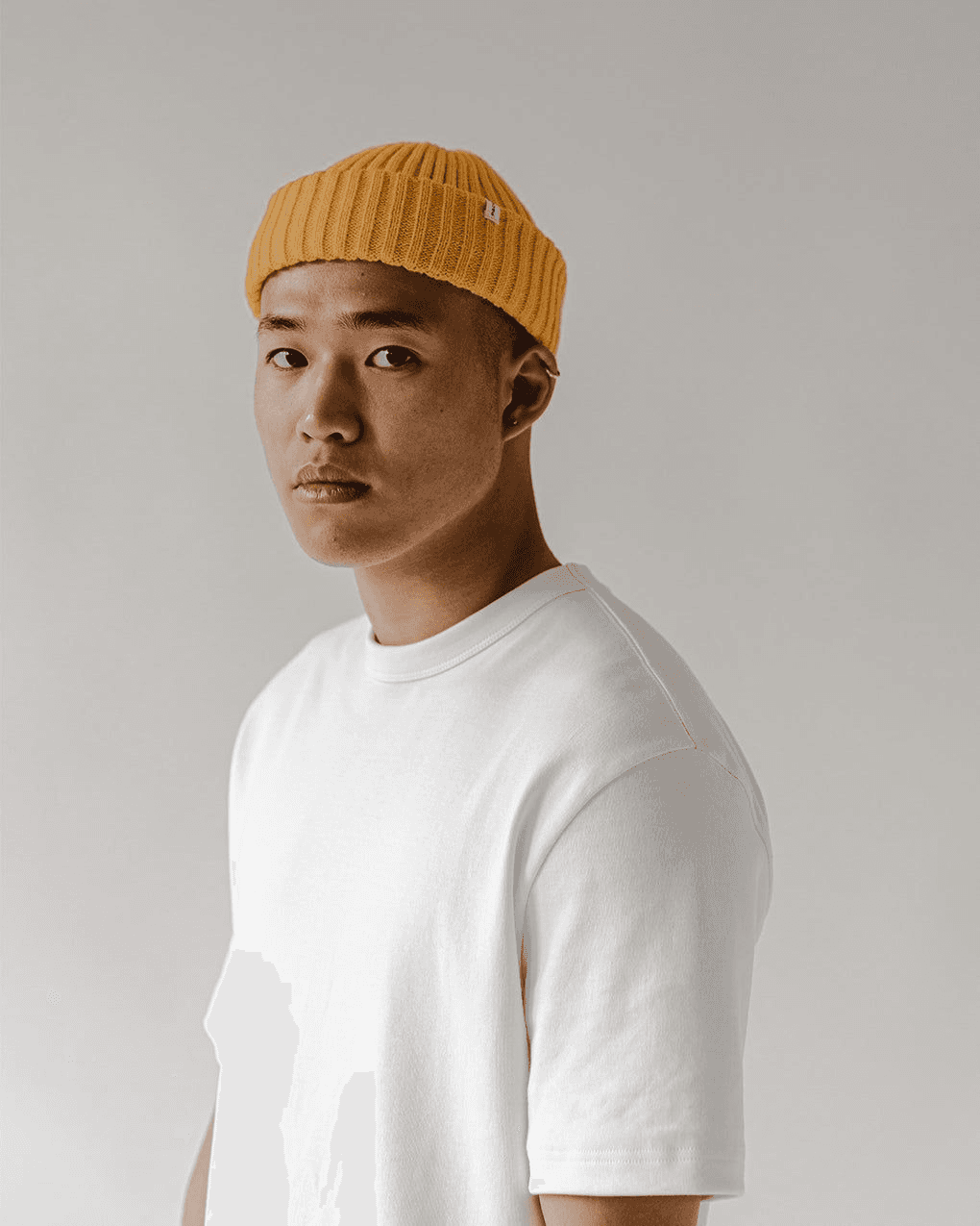 guy with white t-shirt and white background wearing orange cap