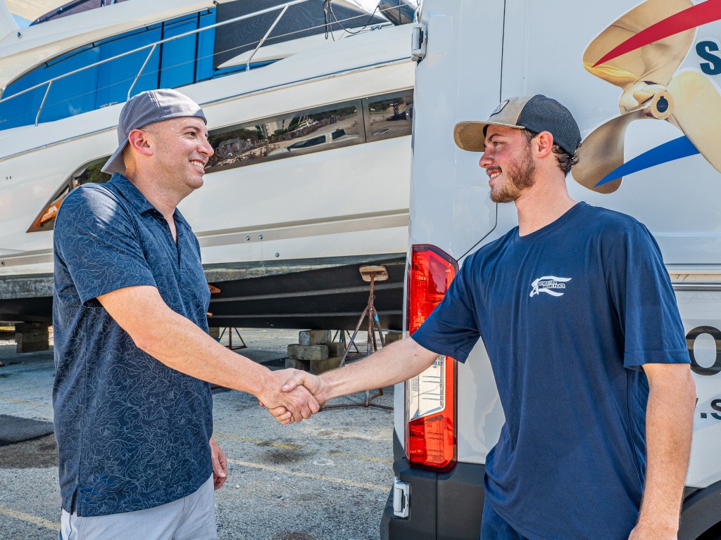 Chris McPherson, Southeastern Marine owner, shaking hands with Southeastern Marine technician