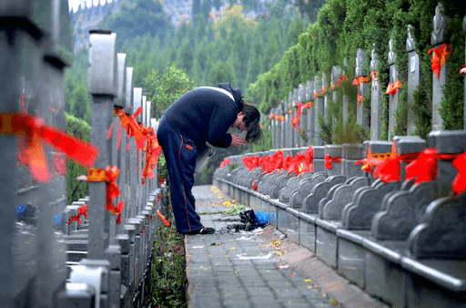 A person shows respect to tombs