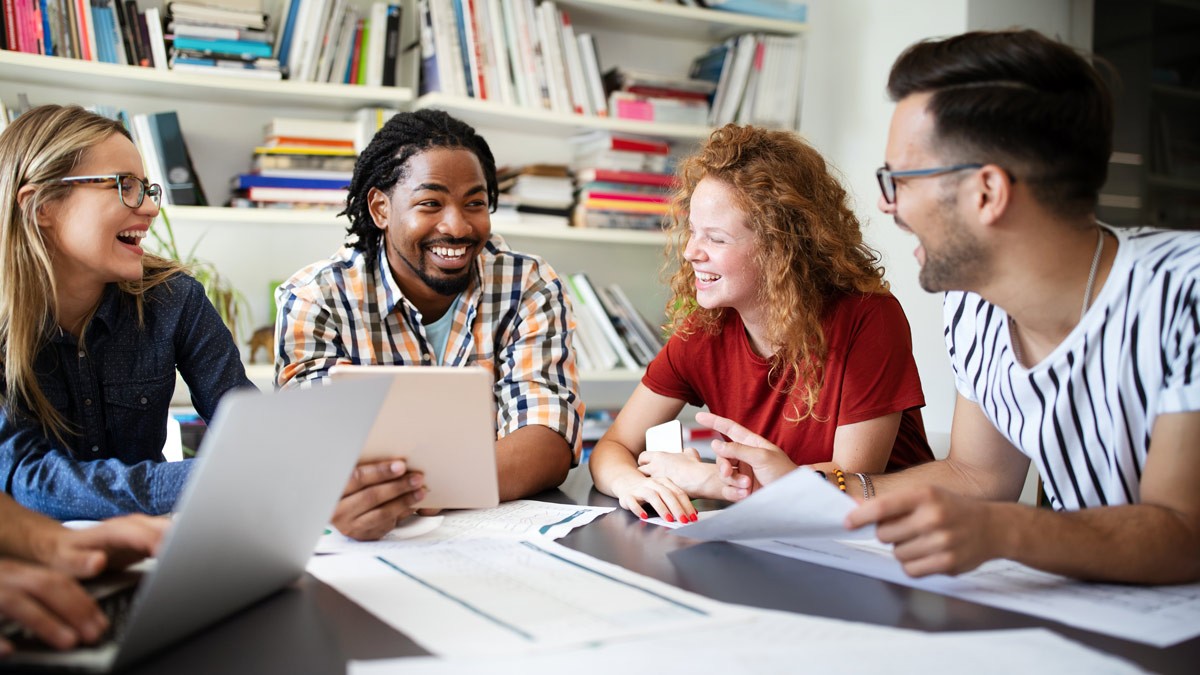 Co-workers sitting around a table and laughing during a meeting