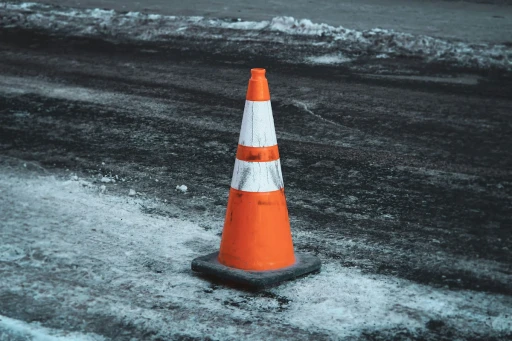 A traffic cone on a winter road symbolizing truck accident