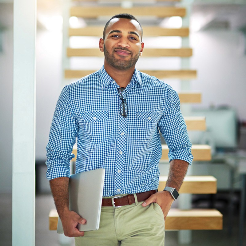 man wearing blue polo shirt with building background