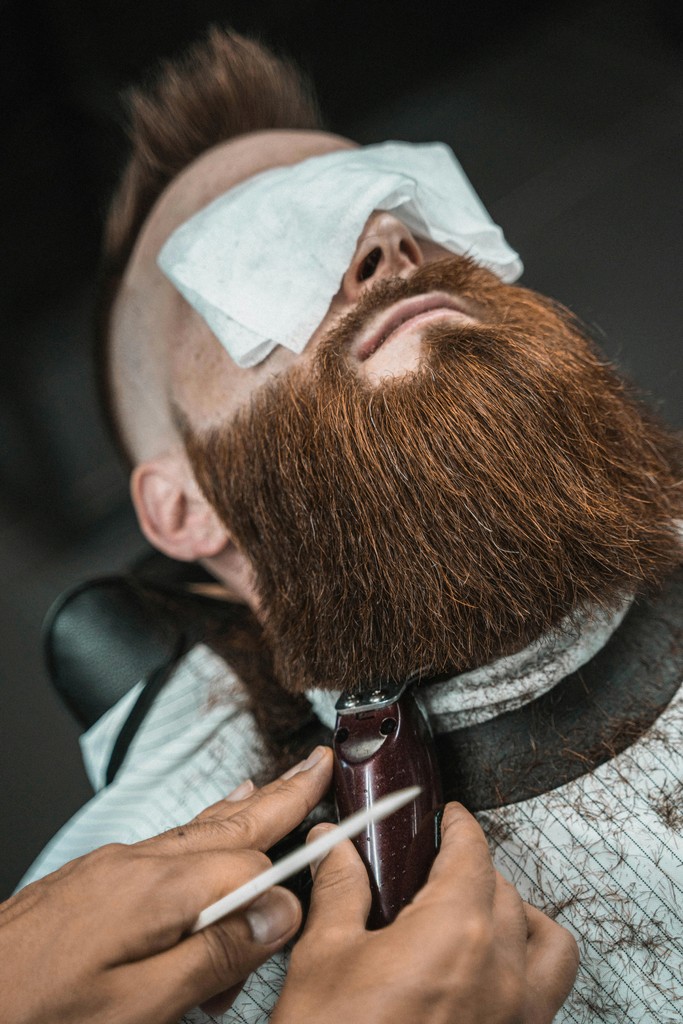 A man getting his hair cut by a barber