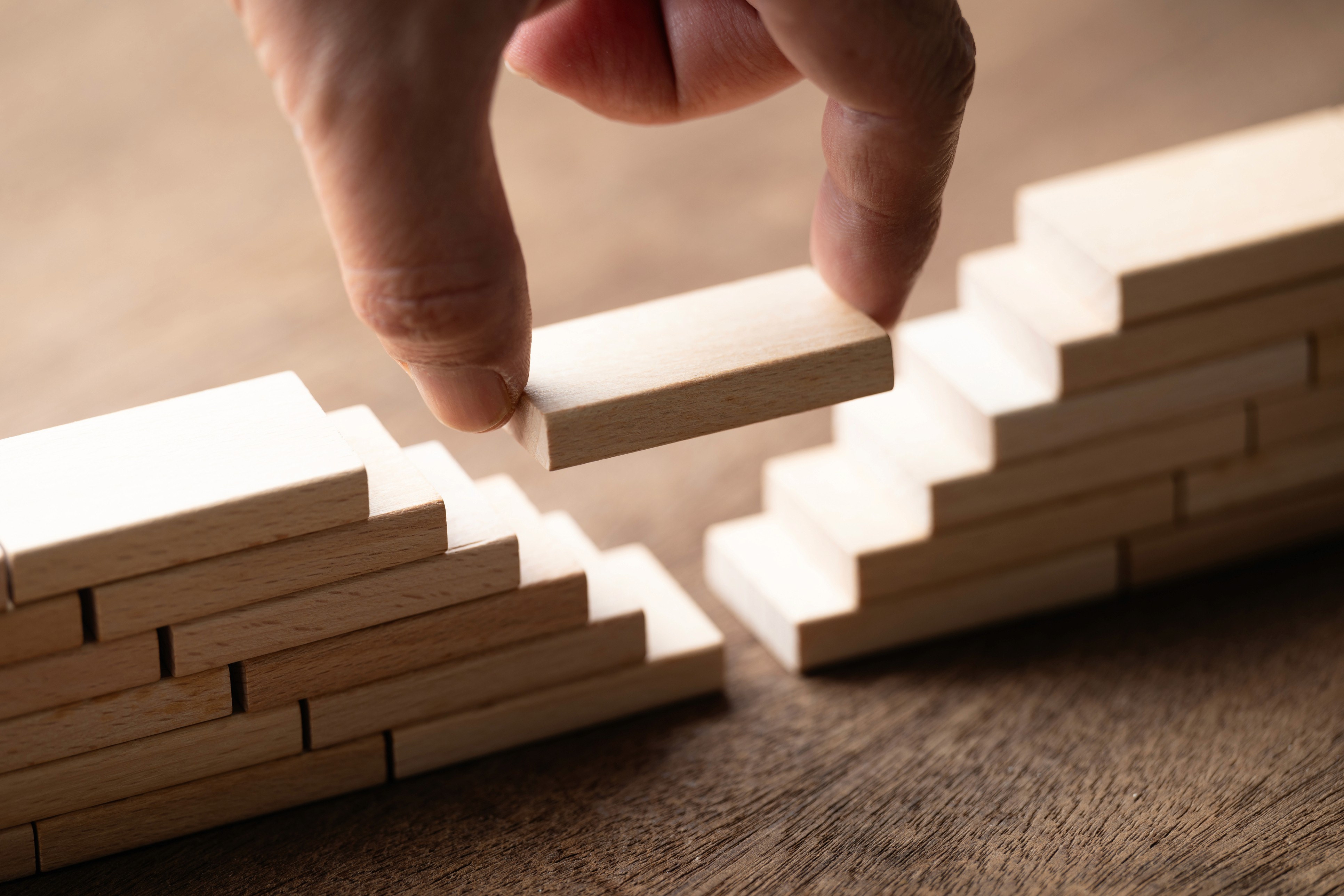 Closeup hand fill the gap between the separated bridge built by the wooden toy, a solution to solve the gap problem