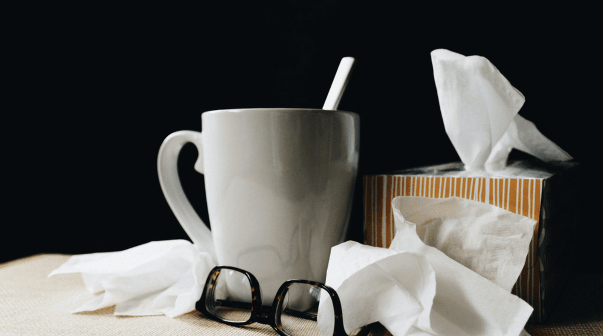 used tissues and hot tea on a desk