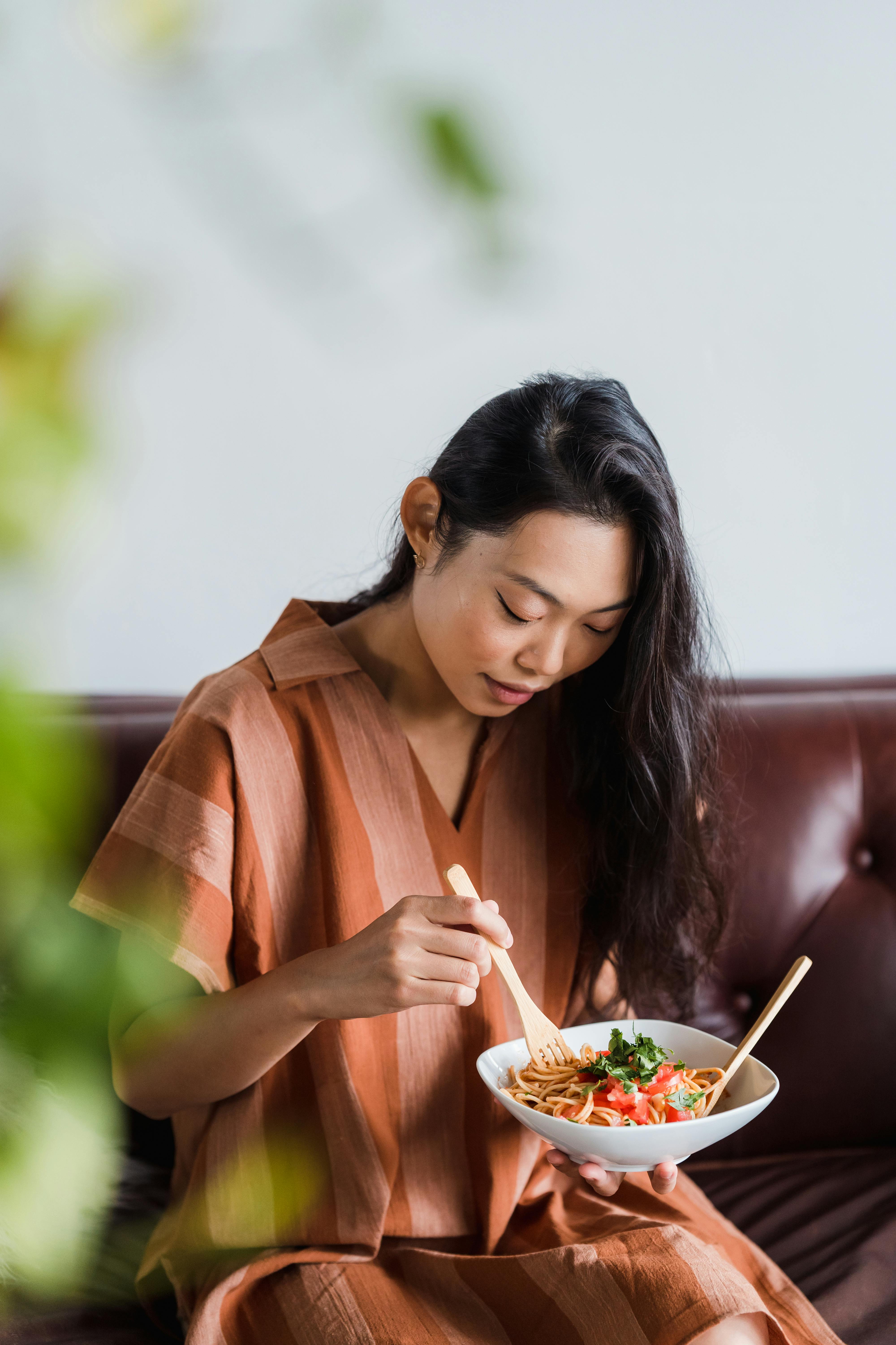 A woman eating a delicious spaghetti